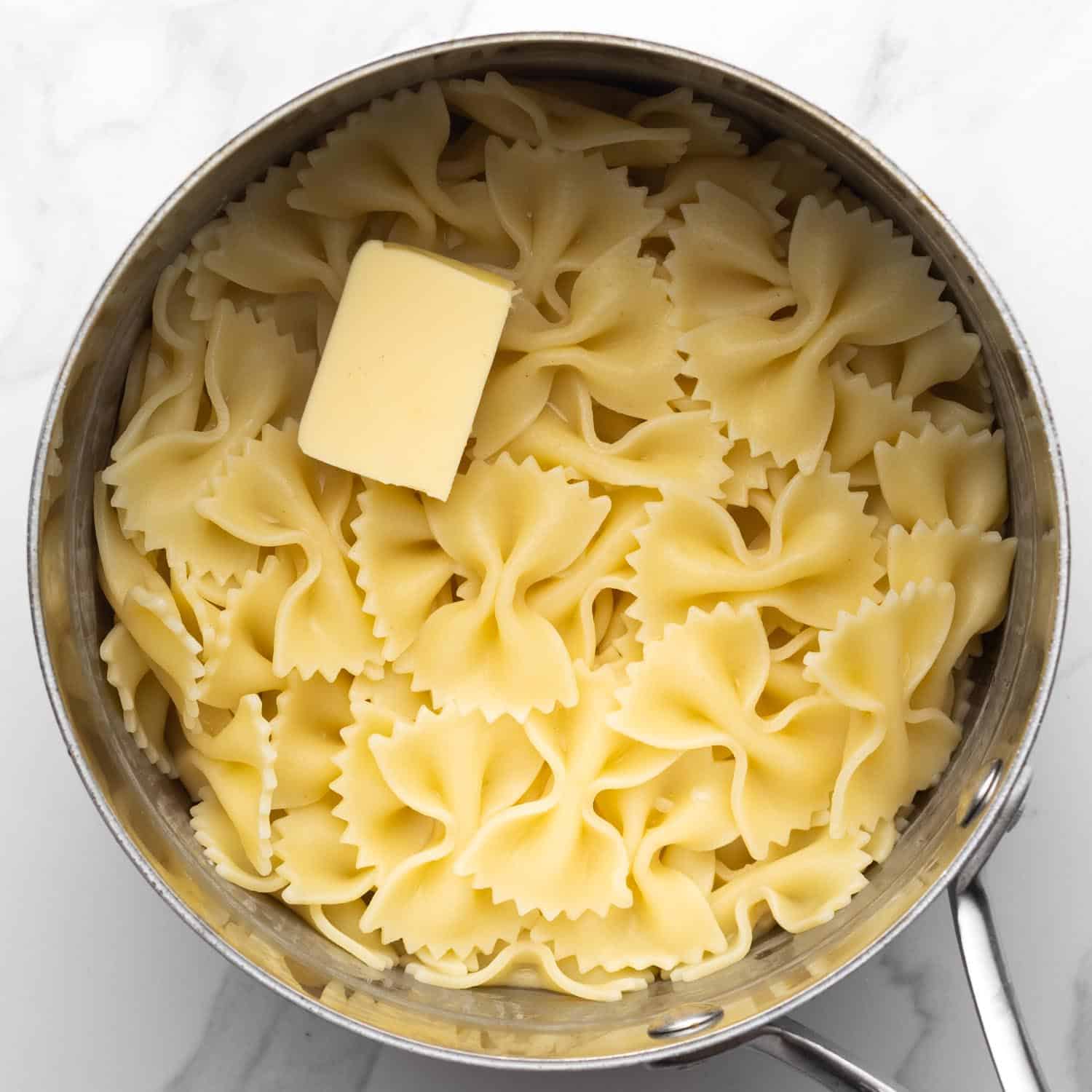 A tabelspoon of butter added to a pot of cooked pasta.