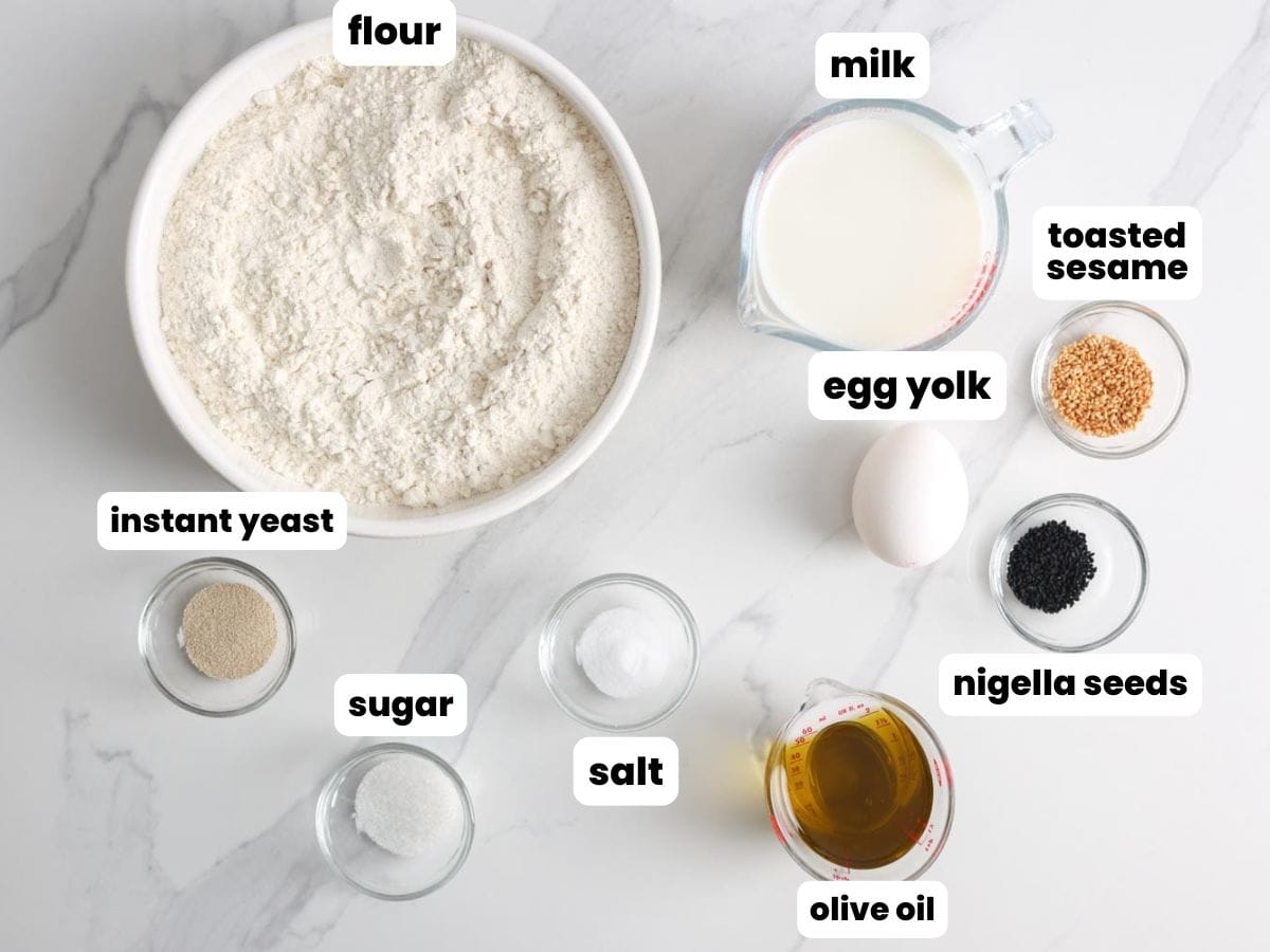 Simple ingredients for Turkish Ramadan bread in small glass bowls on a marble counter. 