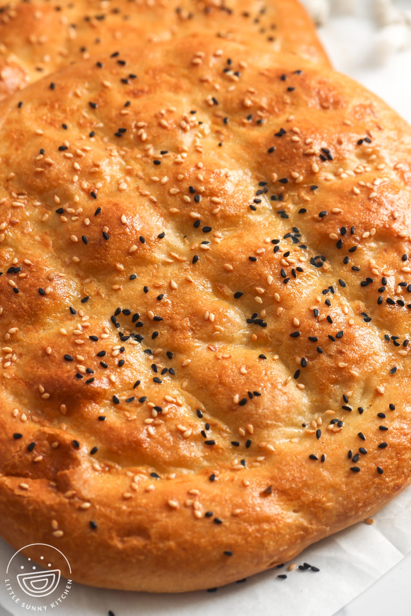 Turkish Pide bread with black nigella seeds and sesame seeds, closeup image to show texture.