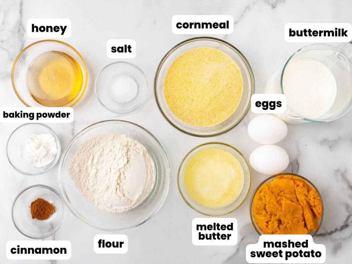 The ingredients for making cornbread with mashed sweet potato, measured into glass bowls arranged on a marble counter