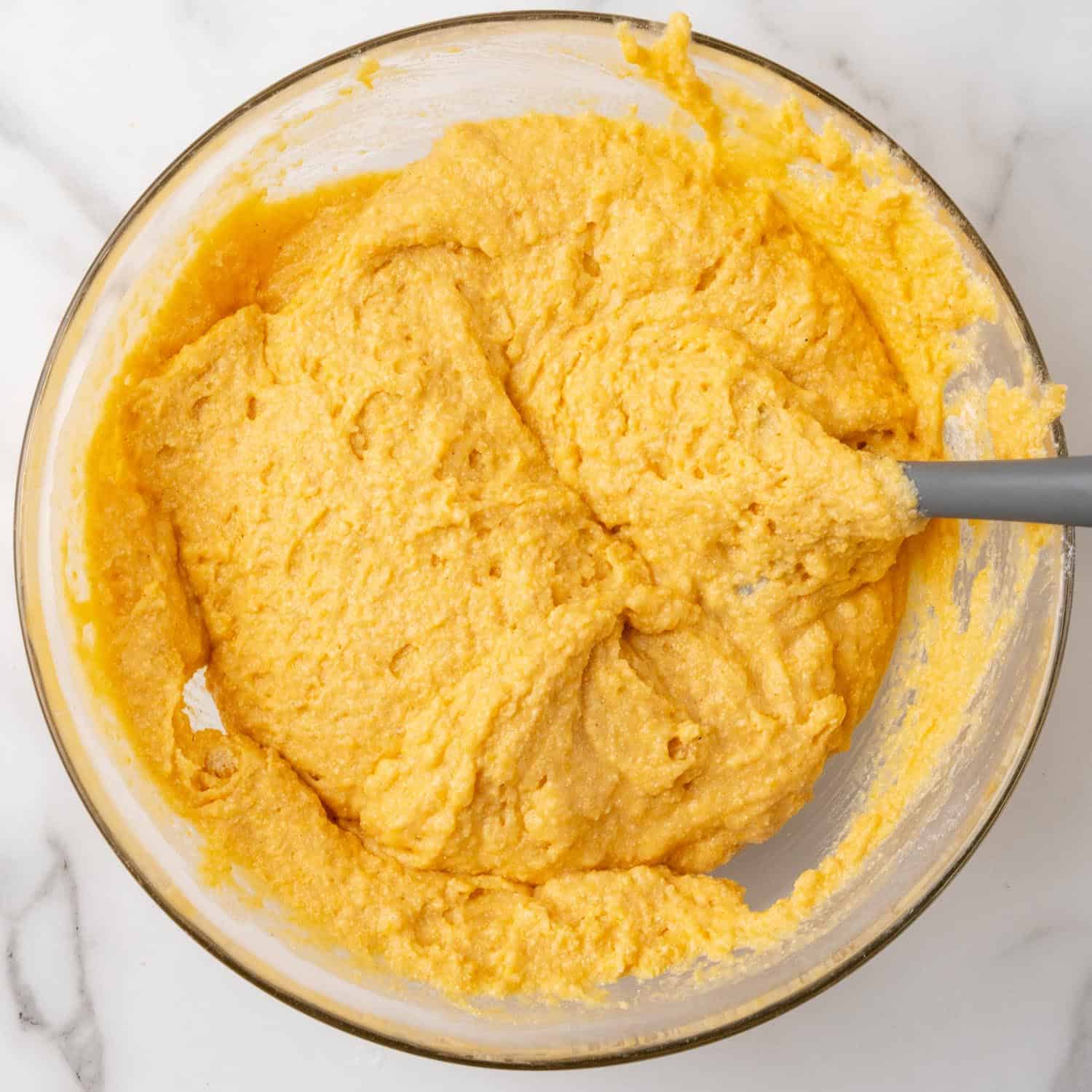 sweet potato cornbread batter in a glass mixing bowl.