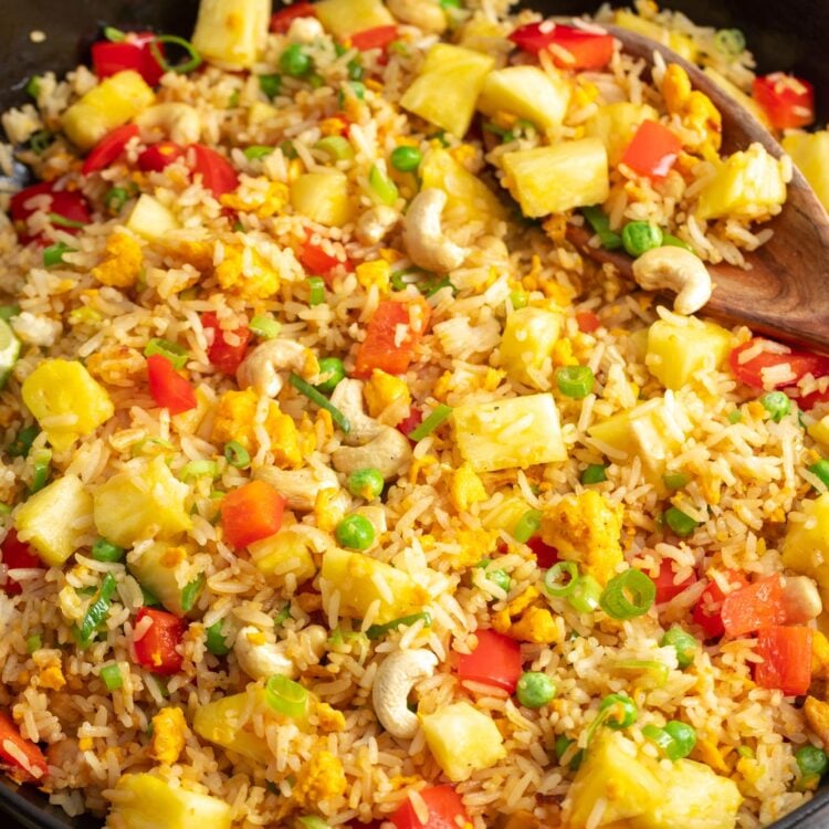 a cast iron skillet filled with Thai pineapple fried rice.