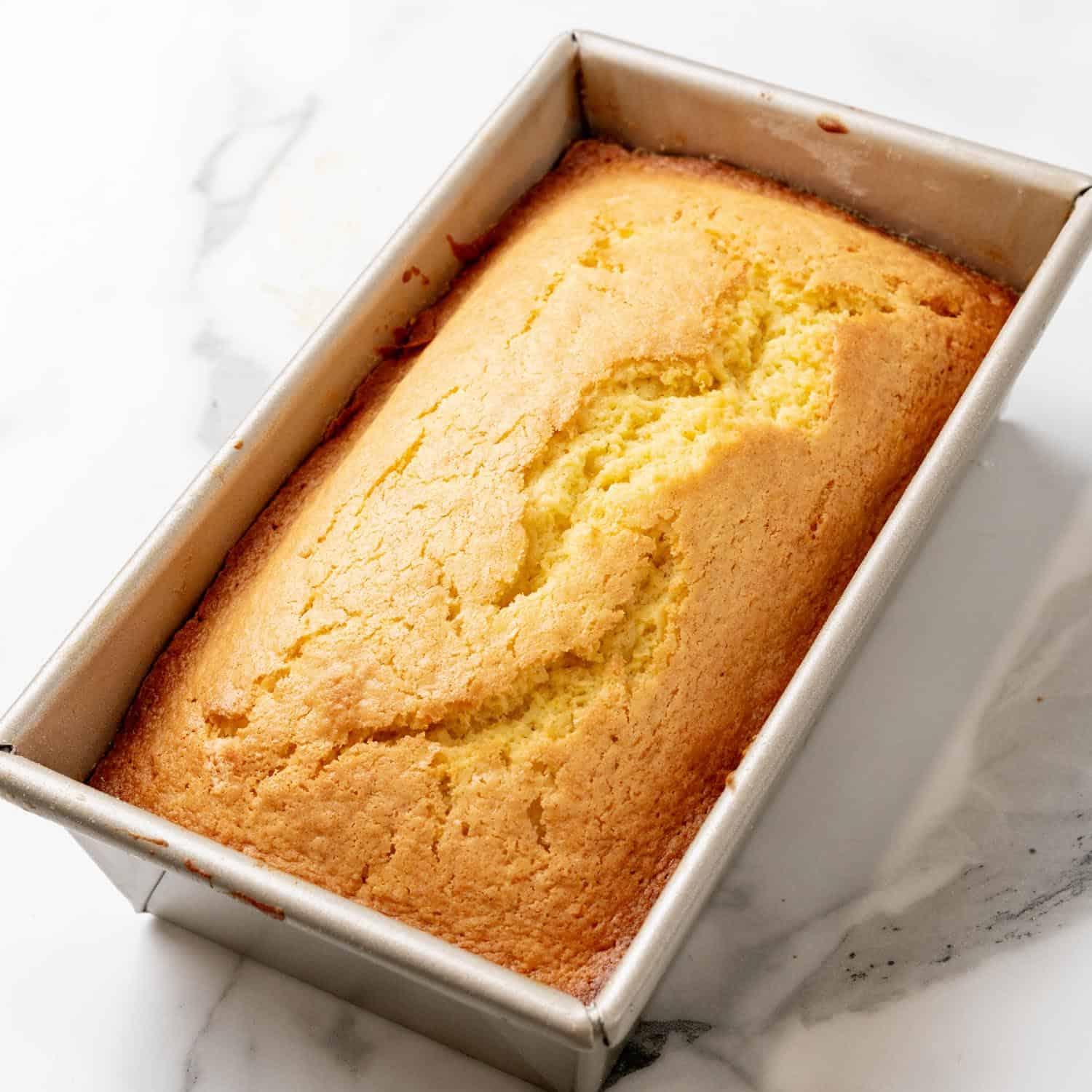 baked starbucks lemon loaf in a metal pan. 