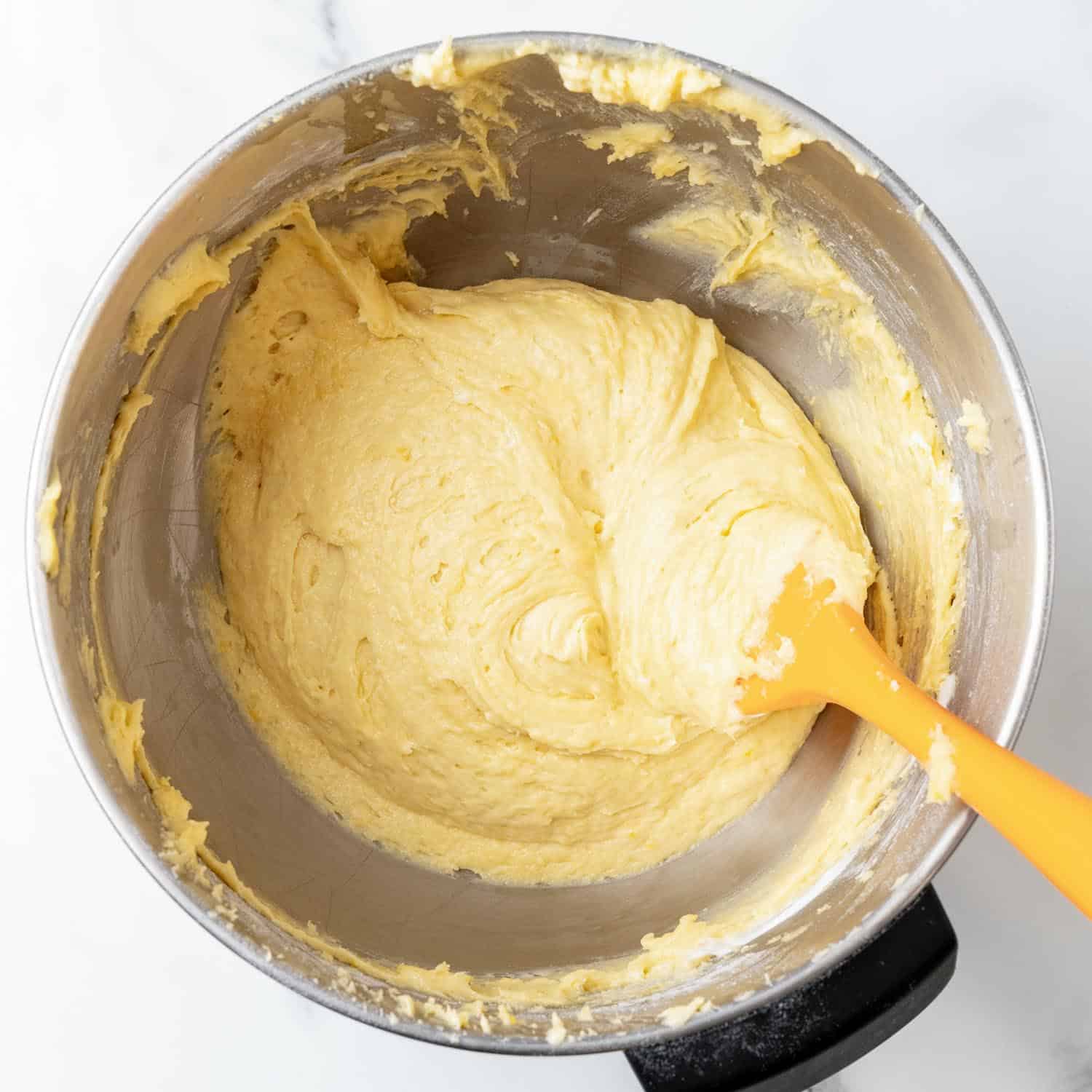 lemon loaf batter mixed together in a stand mixer bowl. 