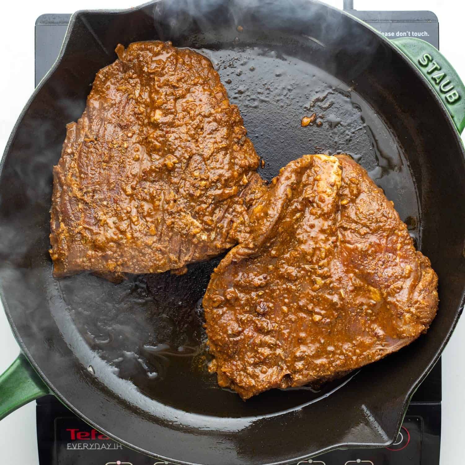 flank steak seared in a cast iron skillet.