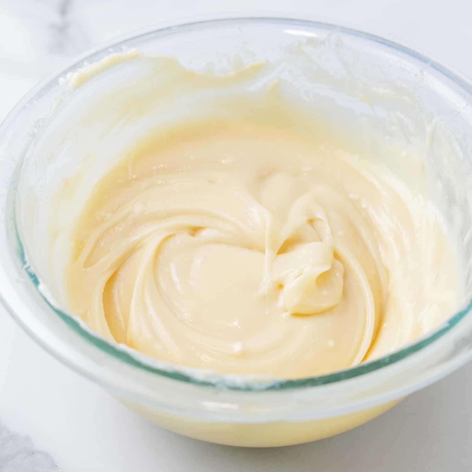 cream cheese filling for pumpkin muffins in a small glass mixing bowl.